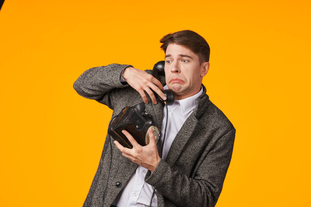 νεαρός άνδρας κρατώντας ρετρό τηλέφωνο στο στούντιο - Φωτογραφία, εικόνα