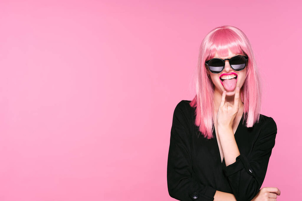 Young woman in pink wig gesturing on pink background - Valokuva, kuva