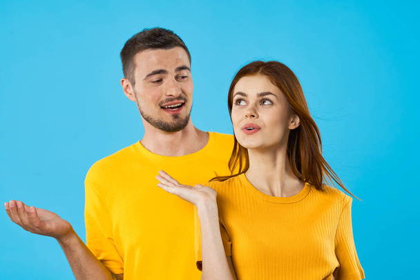 young man and woman in studio  on blue background  - Fotó, kép