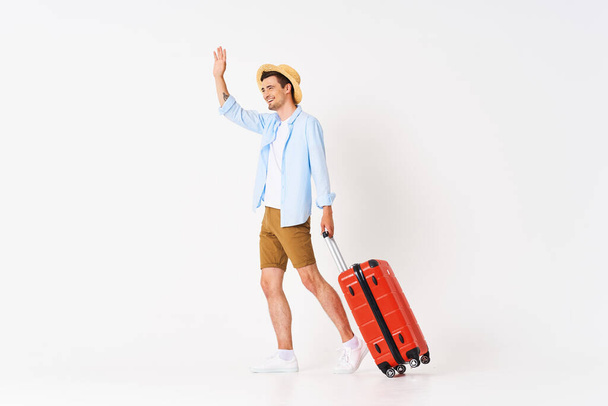 Young man with red suitcase in studio - 写真・画像