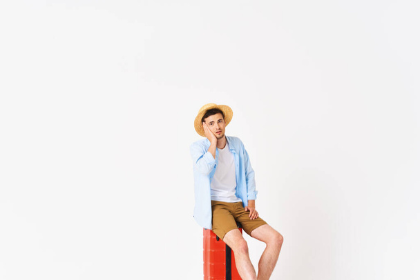 Young man with red suitcase in studio - Fotoğraf, Görsel