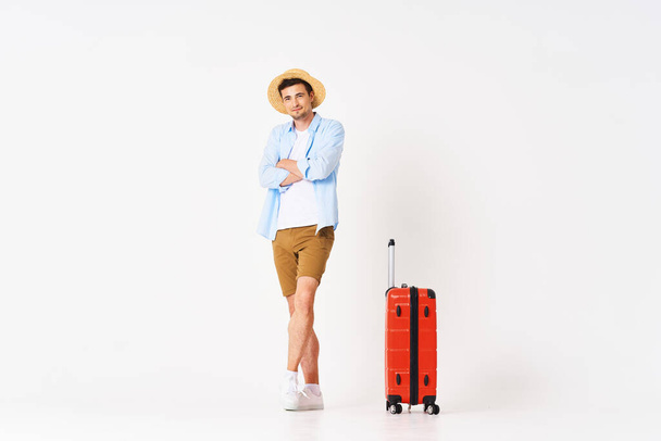 Young man with red suitcase in studio - Photo, Image