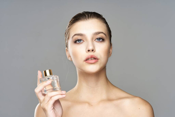 Portrait de jeune belle femme avec flacon de parfum. Plan studio.   - Photo, image