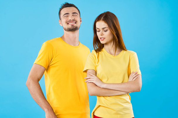 young beautiful couple in  t-shirts posing in studio on isolated background - Fotó, kép