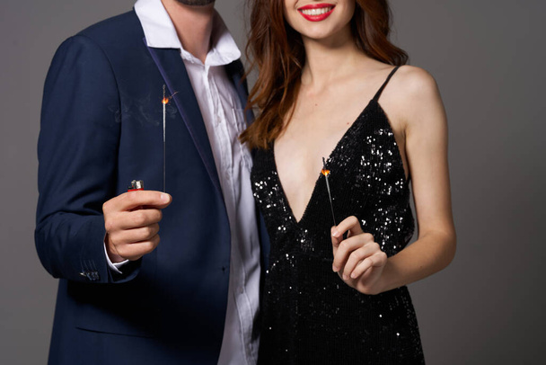 portrait of young beautiful couple celebrating new year with sparklers  - Photo, Image