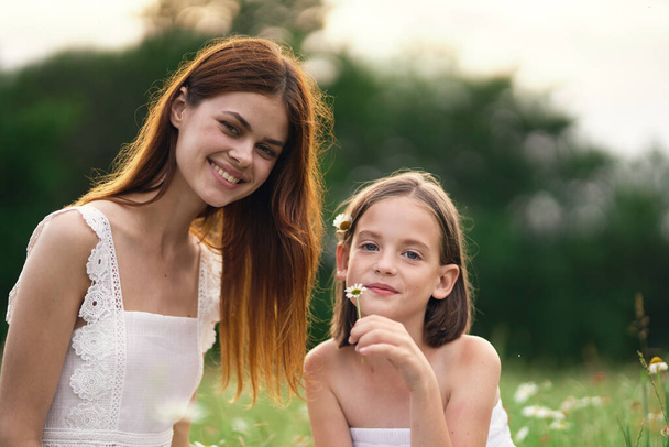 Молода мама і її дочка розважаються на ромашковому полі
 - Фото, зображення