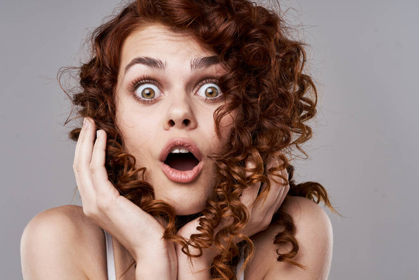 Retrato de jovem bela mulher surpreso com cabelo encaracolado. Estúdio
 - Foto, Imagem