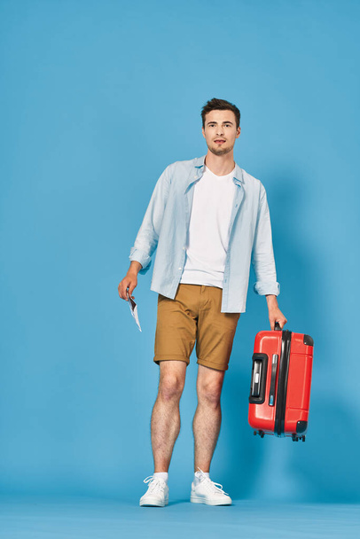 Молодой человек с красным чемоданом в студии
 - Фото, изображение