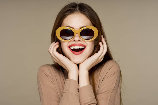 joven hermosa mujer en gafas de sol posando en estudio  - Foto, imagen