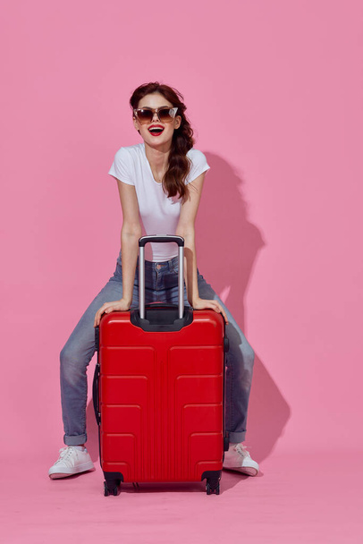 Young woman with red suitcase in studio - Foto, Imagen