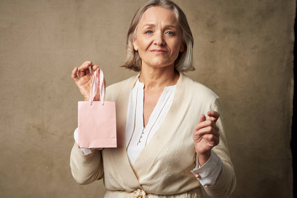 Krásná starší žena s nákupní taškou ve studiu - Fotografie, Obrázek
