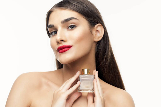 Joven hermosa mujer sosteniendo botella de perfume en el estudio
 - Foto, imagen