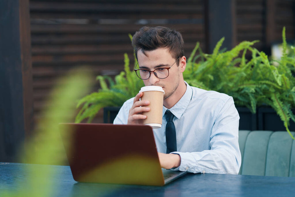 νεαρός όμορφος επιχειρηματίας που εργάζονται με φορητό υπολογιστή στο καφέ - Φωτογραφία, εικόνα