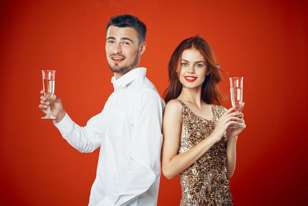 Yeni yılı şampanya ile kutlayan genç ve güzel bir çiftin portresi. - Fotoğraf, Görsel
