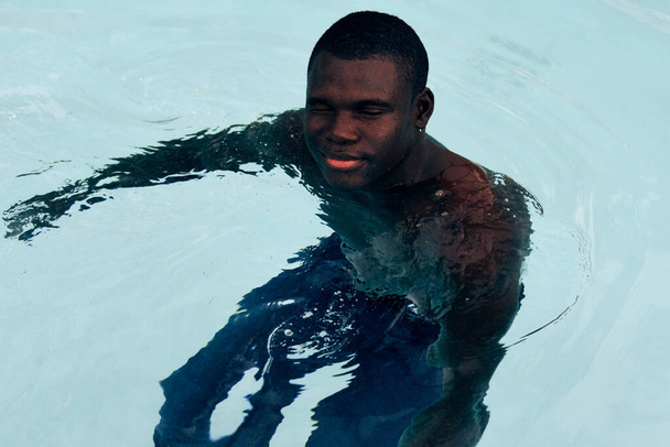 Joven hombre guapo posando en la piscina - Foto, Imagen