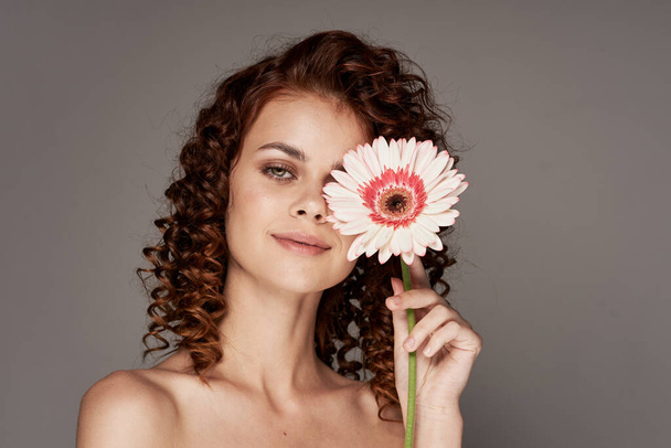 Giovane donna con fiore in posa in studio - Foto, immagini
