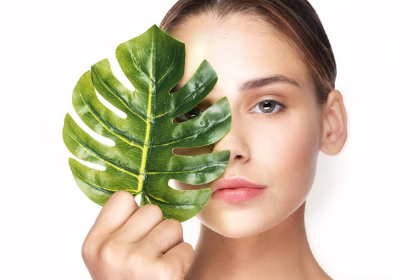 Young beautiful wman  posing with leaf in studio - Foto, Imagen