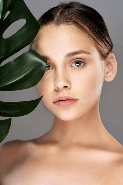 Young beautiful wman  posing with leaf in studio - 写真・画像