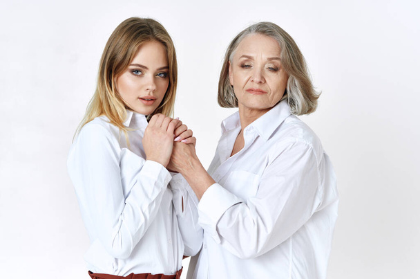 senior woman and young women holding hands    in studio  - Photo, Image