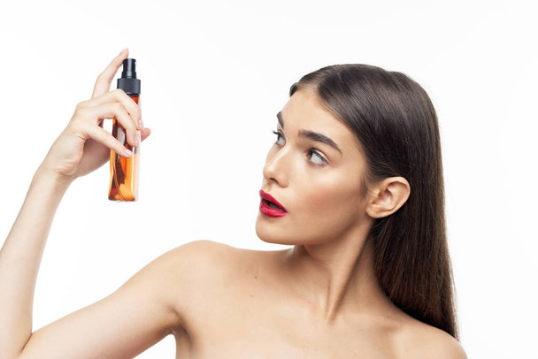 Young beautiful woman with beauty product  in studio  - Фото, зображення