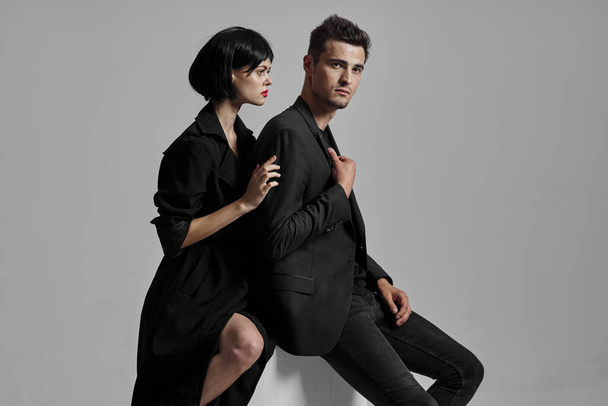 Young beautiful couple in black posing in studio - Фото, зображення