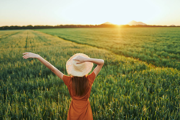 Junge Frau posiert bei Sonnenuntergang auf einem Weizenfeld - Foto, Bild