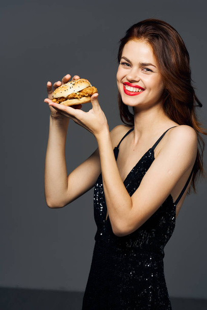 Młoda piękna kobieta z hambyrgerem. Zdjęcia studyjne - Zdjęcie, obraz