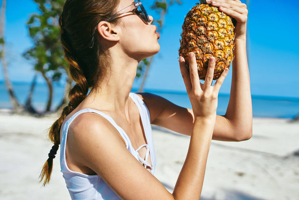 A woman in a white swimsuit with pineapple.  High quality photo - Photo, Image