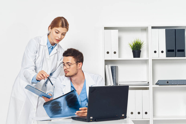 Young doctor with nurse  working with x-ray  in  hospital office  - Zdjęcie, obraz