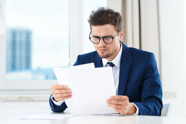 Young  handsome businessman reading documents  - Photo, Image
