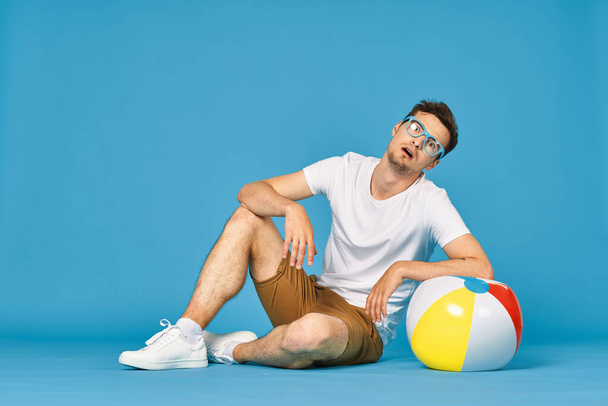 Young man playing with ball in studio  - Foto, afbeelding