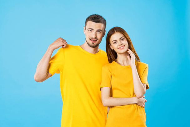 junge Frau und Mann posieren auf blauem Hintergrund  - Foto, Bild