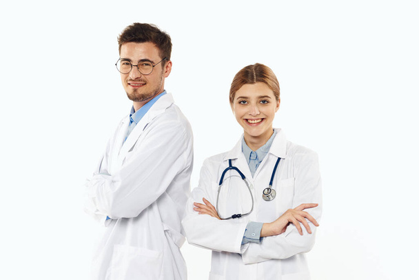 Νεαρός γιατρός και νοσοκόμα στέκεται στο στούντιο, απομονωμένο υπόβαθρο.  - Φωτογραφία, εικόνα