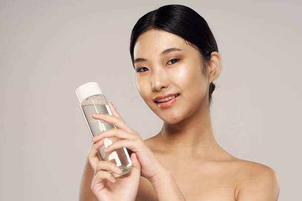 Studio shot. Portrait of young asian woman with beauty product - Foto, immagini