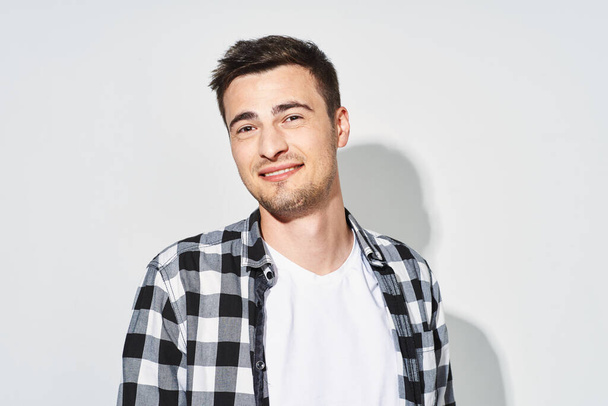 Young handsome man  smiling  in studio,  isolated background - Fotó, kép