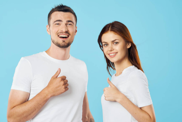 Young beautiful couple with thumbs up in studio  - Photo, Image