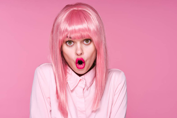 junge schöne Frau mit pinkfarbener Perücke posiert im Studio  - Foto, Bild