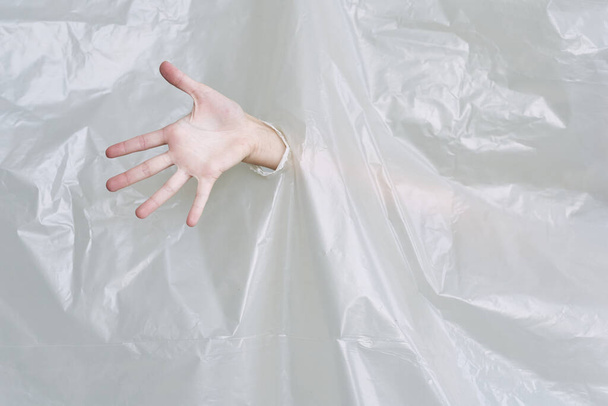 жіноча рука розриває пластик, поліетилен
 - Фото, зображення