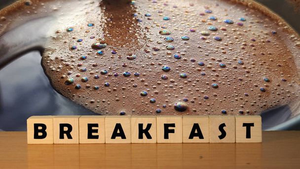 BREAKFAST message word on a wooden desk on cube blocks with a coffee foam background. - Valokuva, kuva