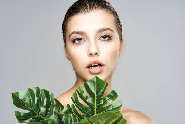 Joven modelo hermosa posando con hojas en el estudio
 - Foto, Imagen