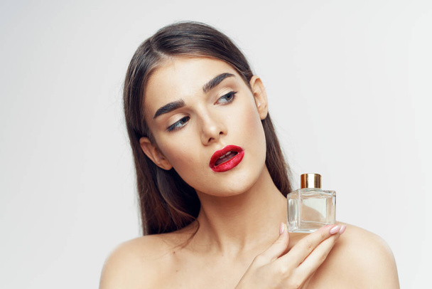 Portrait of young beautiful  woman with perfume bottle isolated on white background - Foto, afbeelding