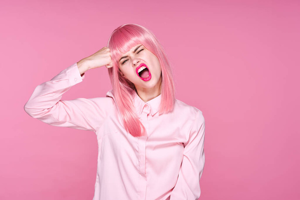 junge schöne Frau mit pinkfarbener Perücke posiert im Studio  - Foto, Bild