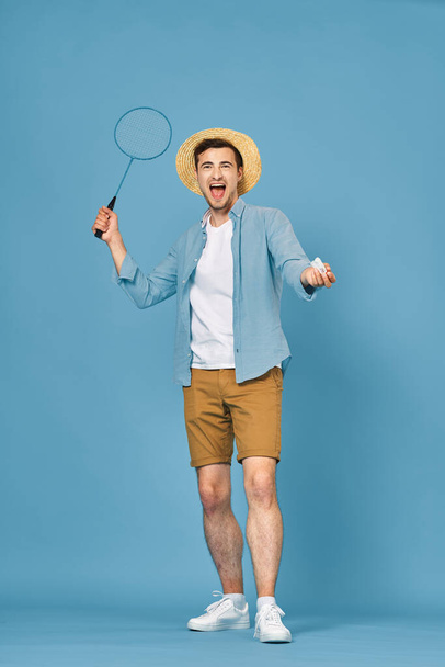 Young man playing tennis isolated on blue background, studio shot - Фото, зображення