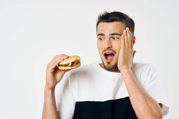 Young man with hamburger in studio  - Foto, Imagen