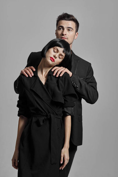 Молодая красивая пара в черном позирует в студии
 - Фото, изображение