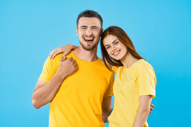 young beautiful couple in  t-shirts posing in studio on isolated background - Foto, Imagen