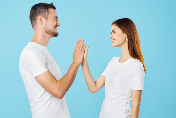 Young beautiful couple  in studio giving high five  - Photo, Image