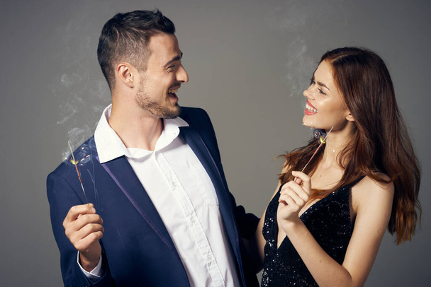 portrait of young beautiful couple celebrating new year with sparklers  - Фото, изображение
