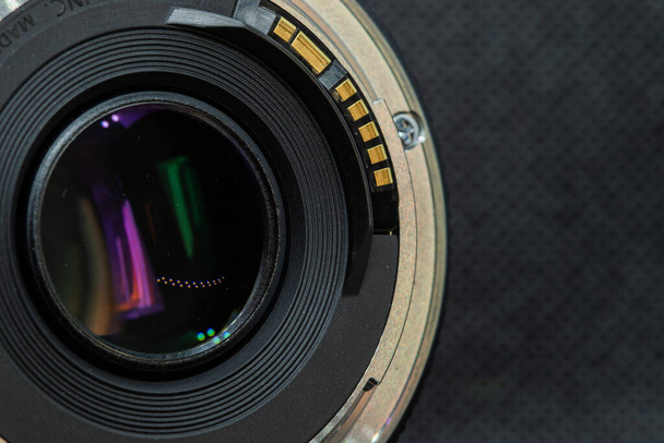 Macro closeup φωτογραφία του φακού στην κάμερα DSLR σε σκούρο φόντο προβολή των επαφών που συνδέουν την επικοινωνία με την κάμερα. - Φωτογραφία, εικόνα