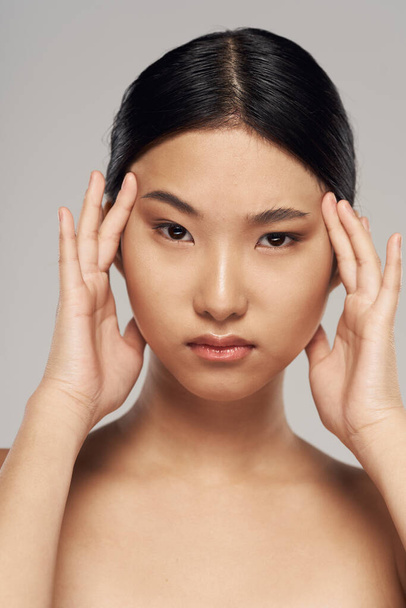 Portrait of young beautiful asian woman with headache    isolated   - Fotografie, Obrázek